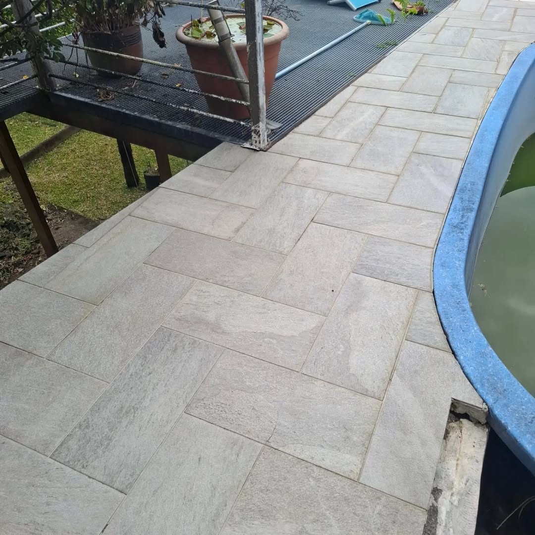 Allée dallée le long d'une piscine, propre et sèche